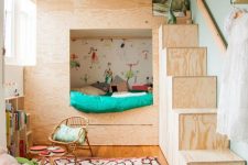 41 a small shared kids’ space with a plywood bunk bed with colorful bedding, a printed rug, a bookshelf and a basket with toys
