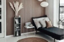 a Scandinavian space with a black lounger, a lightweight nightstand and a storage unit, pendant lamps and a jute rug