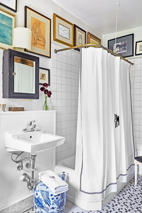 a beautiful neutral bathroom with square and mosaic tiles, a gallery wall that goes right under the ceiling and vintage appliances