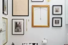 a black and white mudroom with a quirky gallery wall that flows from one wall to another and a candle lantern