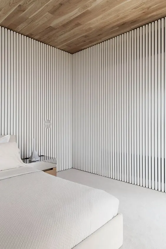 a minimalist bedroom with white wood slat walls or space divides that separate it from the rest of the space
