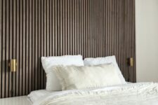 a neutral bedroom with a dark-stained wood slat accent wall, white nightstands, a bed with neutral bedding