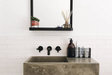 a polished concrete floating sink, black fixtures and a mirror in a black frame for a chic and beautiful bathroom look in modern style