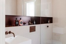 a small and chic modern bathroom with small scale tiles, a mirror cabinet, a burgundy niche shelf and a floating sink