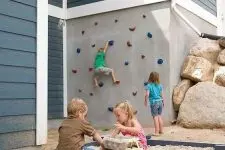 05 an outdoor kids’ playspace with a climbing wall, rocks and a sandbox is a great space for lots of children