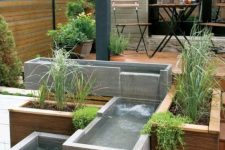 06 a modern outdoor space clad with a wooden deck, with a modern waterfall of concrete boxes and greenery is a cool and edgy nook