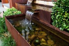 10 a modern waterfall with several faucets and bowls, with rocks inside and greenery around is a cool idea for a modern garden