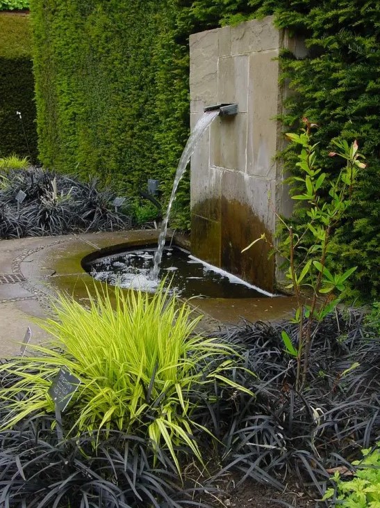 a modern fountain clad with stone, with a metal touch is a lovely idea for a modern or zen-like garden