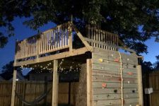 22 a treehouse platform built around a living tree, featuring a climbing wall and rope is a lovely idea for outdoors