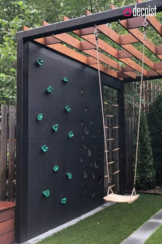 a kids' playground with a swing, a climbing wall and a wall with cutout circles will let your kids be active and have fun