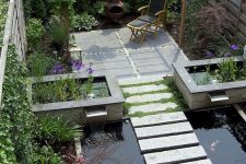 32 a modern outdoor space with a deck, a dining set, a pond with stone steps, a stone deck with some furniture and water gardens