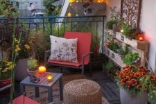 a bright eclectic terrace with a couple of metal chairs and side tables, a rug, lights and potted blooms and greenery