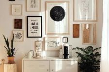 a chic gallery wall with mismatching neutral and black frames, with various creative art in neutrals and black