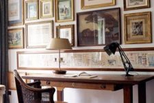 a chic vintage home office with a stained desk and a chair, a large vintage gallery wall and a couple of lamps