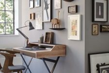 a delicate vintage home office with grey walls, a vintage-inspired desk and a chair, a vintage gallery wall that is extended to the next wall