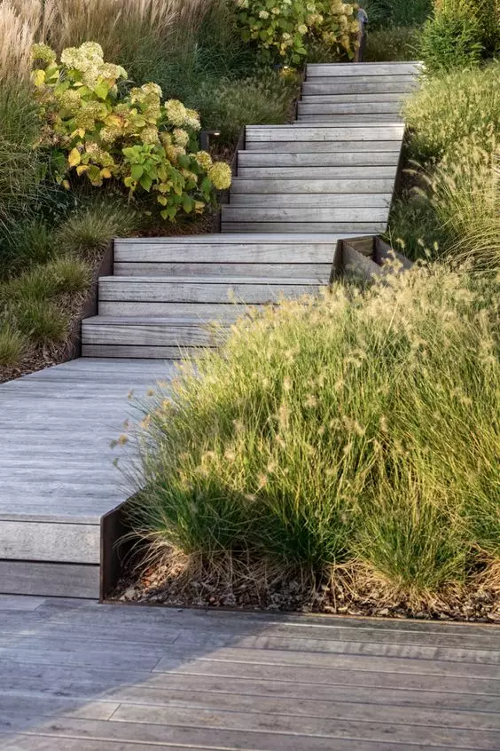 a laconic weathered wood wooden walkway with steps is a lovely idea for a rustic space, it feels a bit coastal and relaxed