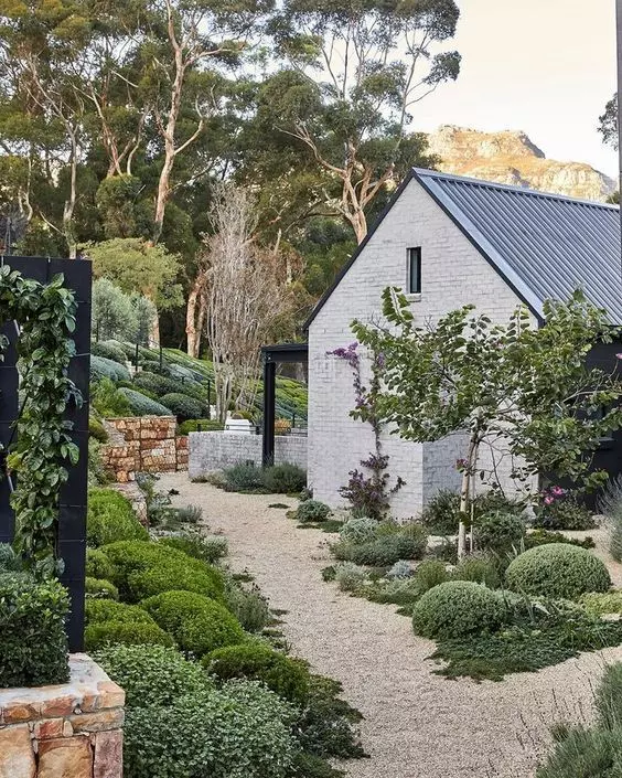 a lovely modern farmhouse garden with greenery and shrubs, with gravel pathways is a cool idea to steal