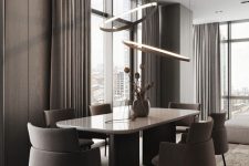 a sleek contemporary dining space with taupe wood panel walls, a large table and taupe chairs, lovely pendant lamps