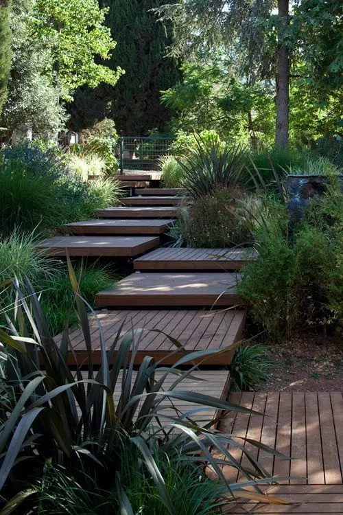 A wooden walkway placed of wooden pallet like tiles is a lovely idea for a modern or contemporary garden and adds a warm feel to the space