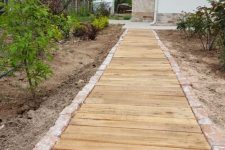 a wooden walkway with a stone edge is a cool rustic idea for many outdoor spaces and is easy to construct yourself