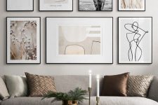 an elegant free form gallery wall with thin black frames and white mats plus muted color and black and white art
