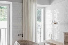 16 a minimalist neutral bathroom with grey walls, white subway tiles, a wooden floating bench and a stone tub plus windows and curtains under the ceiling to highlight the double height