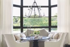 20 a monochromatic dining space with a large bow window done with semi sheer draperies that match the color scheme and make the space cozier