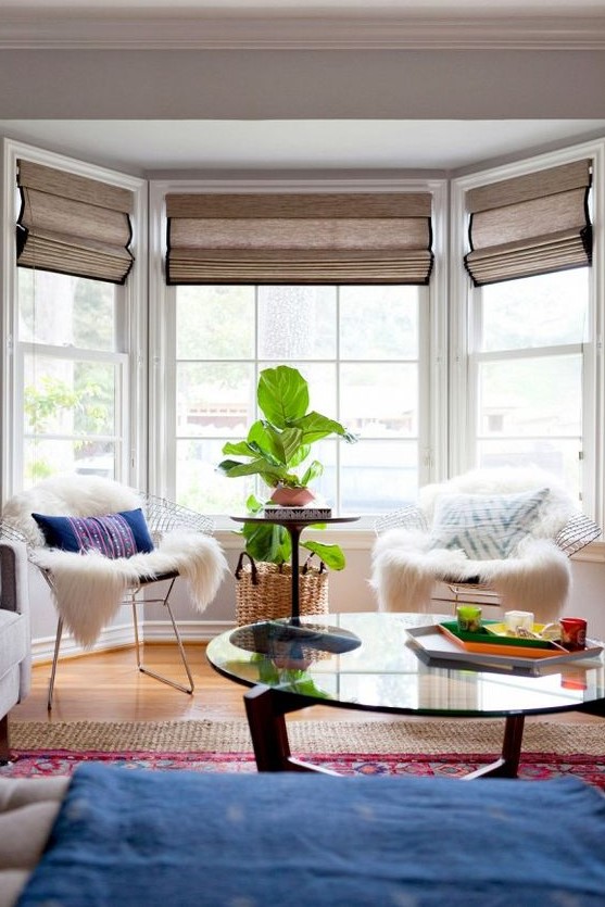 a stylish bay window featuring matching blinds that are neutral in the space and good to block out the sun