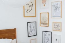 a catchy gallery wall covering the corner with blonde wood, white and black frames, white matting and some abstract art