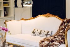 a contrasting contemporary space finished off with a beautiful vintage white sofa with gilded framing
