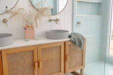 a double vanity with cane doors, round concrete sinks, round mirrors composes a very chic bathing space