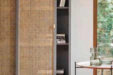 a grey bookcase with sliding cane doors is a very fresh and innovative solution that looks modern and bold thanks to the color combo