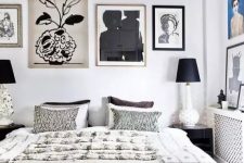 a high contrasting bedroom with a bed and printed bedding, several gallery wall, printed rugs and black table lamps