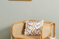 a rattan and cane chair with a printed boho pillow is a gorgeous modern accent piece for any room, it cna fit a modern or a boho interior