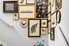 a vintage gallery wall taking the corner, with mismatching black and gold frames and pretty black and white vintage art