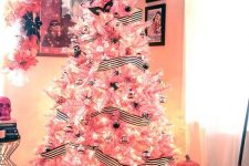 04 a pink Halloween tree decorated with striped garlands, black spiders, black and clear ornaments, lights and masks is a lovely idea