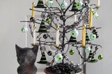 14 a black Halloween tree with black and green ornaments, large eyeball ones, white and gold candles is amazing