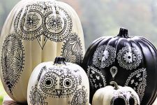 16 black and white pumpkins decorated with black and white sharpies, portraying owls, are a great idea for a boho Halloween
