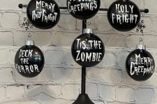 18 a metal Halloween tree with greenery and black ornaments with white letters – you can DIY some for your tree
