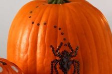 25 a natural orange pumpkin decorated with black sequins showing a spider is a beautiful and very cool idea that you can realize last minute