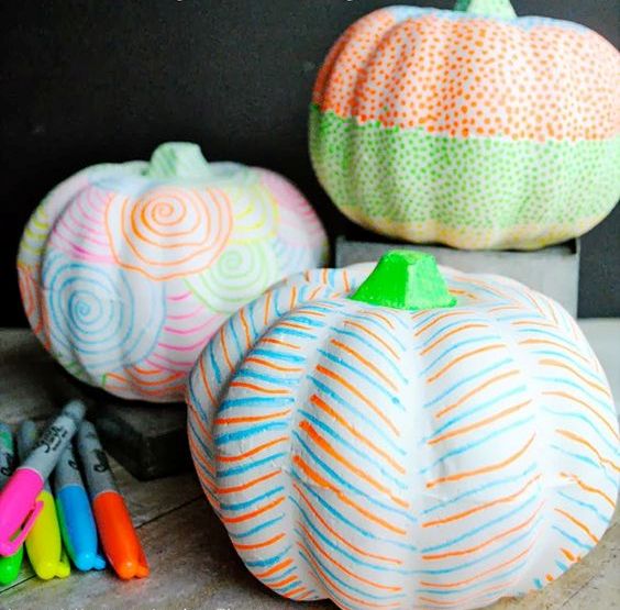 white pumpkins made super colorful using colorful sharpies is a great idea for modern and bright Halloween