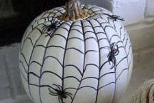 30 a super simple and cool Halloween pumpkin design done with a sharpie and black plastic spiders is a lovely idea to try