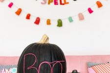 31 black pumpkins decorated with neon wire letters look bold, modern and super cool and will match your modern and bright Halloween party