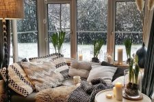 a bay window as a sleeping zone, with a large daybed, lots of boho pillows and blankets, candles and a side table is amazing