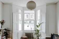a bay window with a radiator, a potted plant, a lamp and a stool – this is a cool way to use an awkward space
