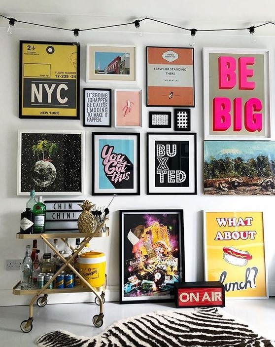 A colorful pop art gallery wall in various colors   posters for fun and with black and white frames is a bold idea