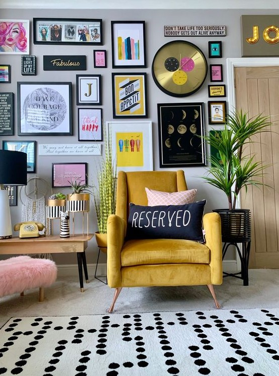 a stylish colorful gallery wall with matching black frames, colorful artworks and posters, a glam clock and bold prints
