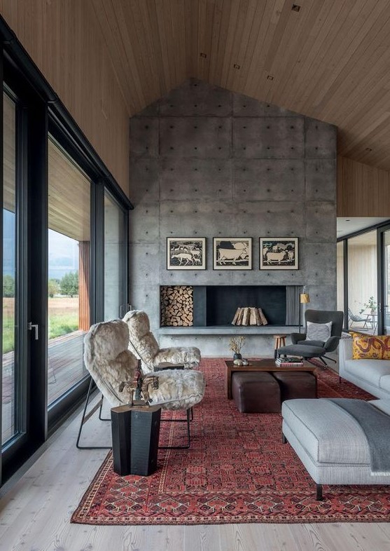 a welcoming modern living room with an oversized concrete fireplace, chic furniture and printed textiles is very cool