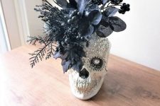 04 a Gothic Halloween decoration of an embellished skull with sequins and a pearl plus faux black blooms and leaves