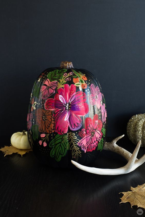 A jaw dropping Halloween pumpkin   a black one with painted bold blooms and butterflies just wows